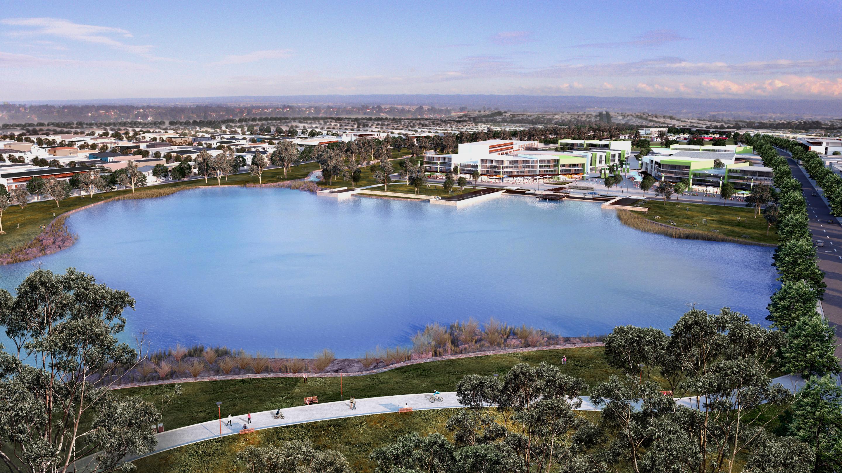 View of lake in the evening, surrounded by properties and grassland